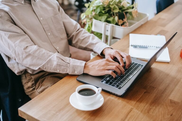 unrecognizable man working remotely on laptop at home